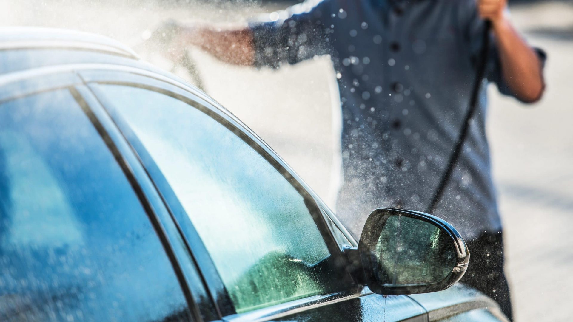 Caucasian Men Cleaning Vehicle in the Car Wash. Closeup Photo. Automotive Theme.